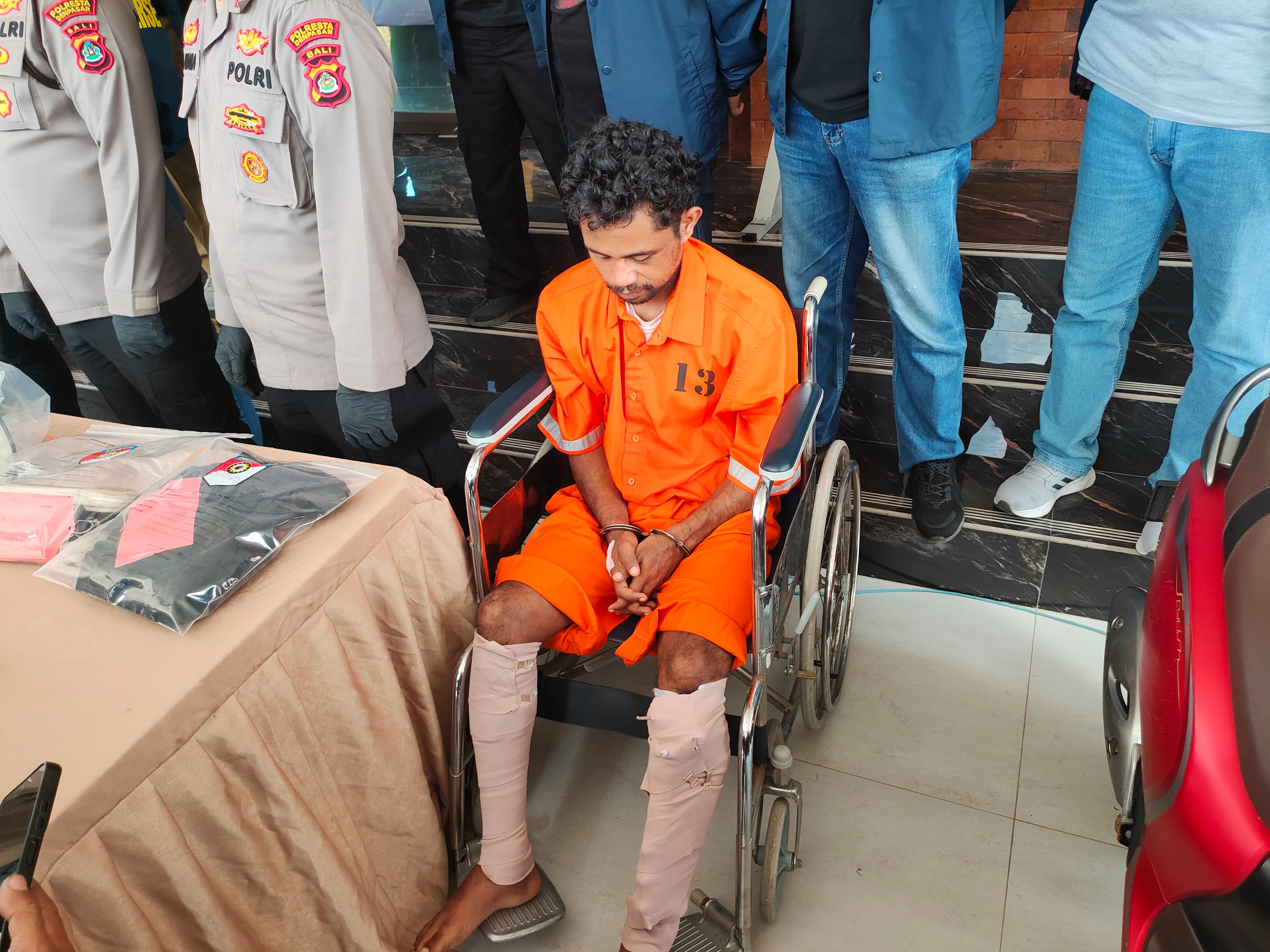 Viktorius menggunakan kursi roda karena kakinya didor petugas. (Bali Express/I Gede Paramasutha)