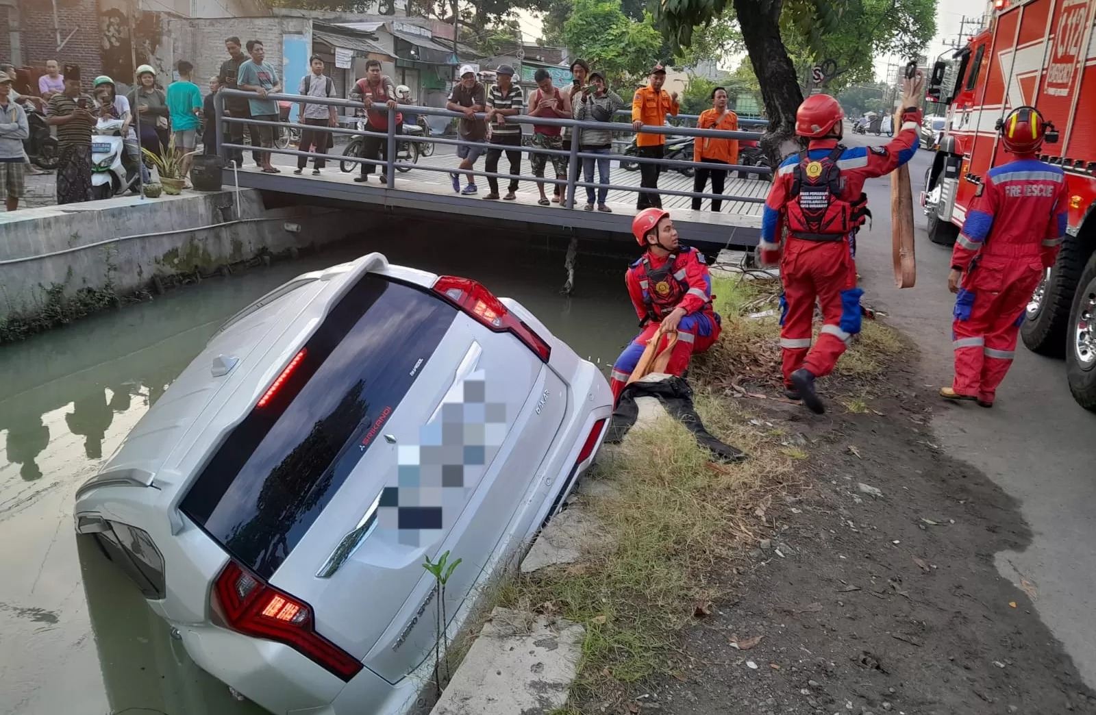 DIANGKAT : Petugas DPKP Surabaya mengevakuasi mobil Mitsubishi Pajero yang tercebur ke sungai di Menur Pumpungan, Surabaya.