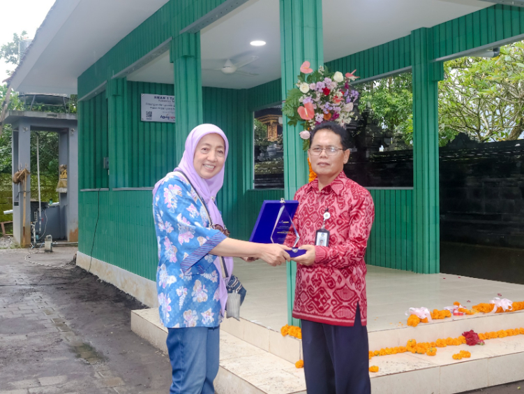Komisaris Agung Concern, Nani Koespriani menyerahkan plakat kepada kepala SMAN 1 Tabanan, I Made Wardita.