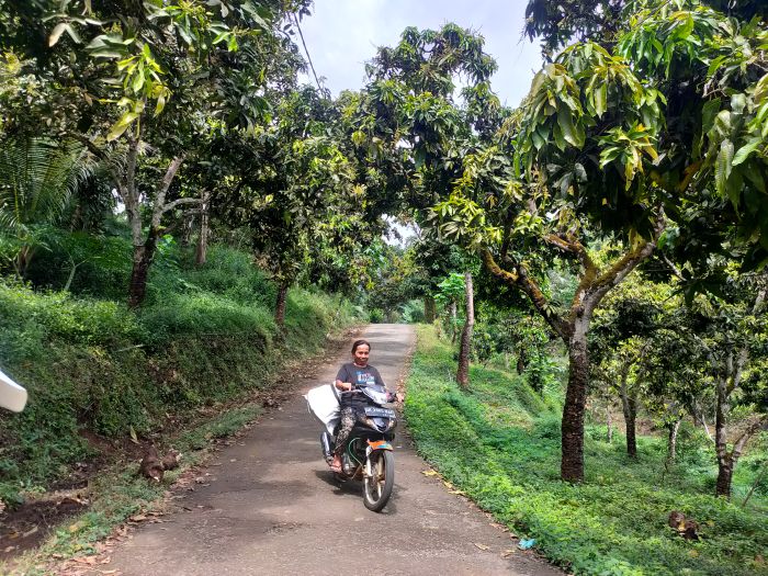 Warga yang melintas di jalan yang sudah dibeton.