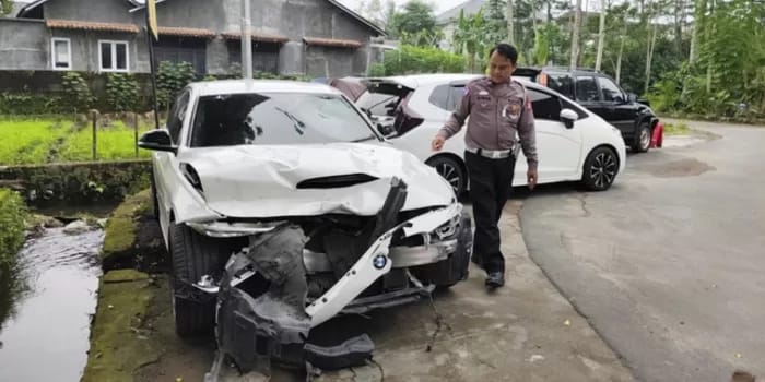 KAP RINGSEK: Mobil BMW dengan nomor polisi B 1442 NAC yang  dikemudikan Christiano ringsek di bagian kap.