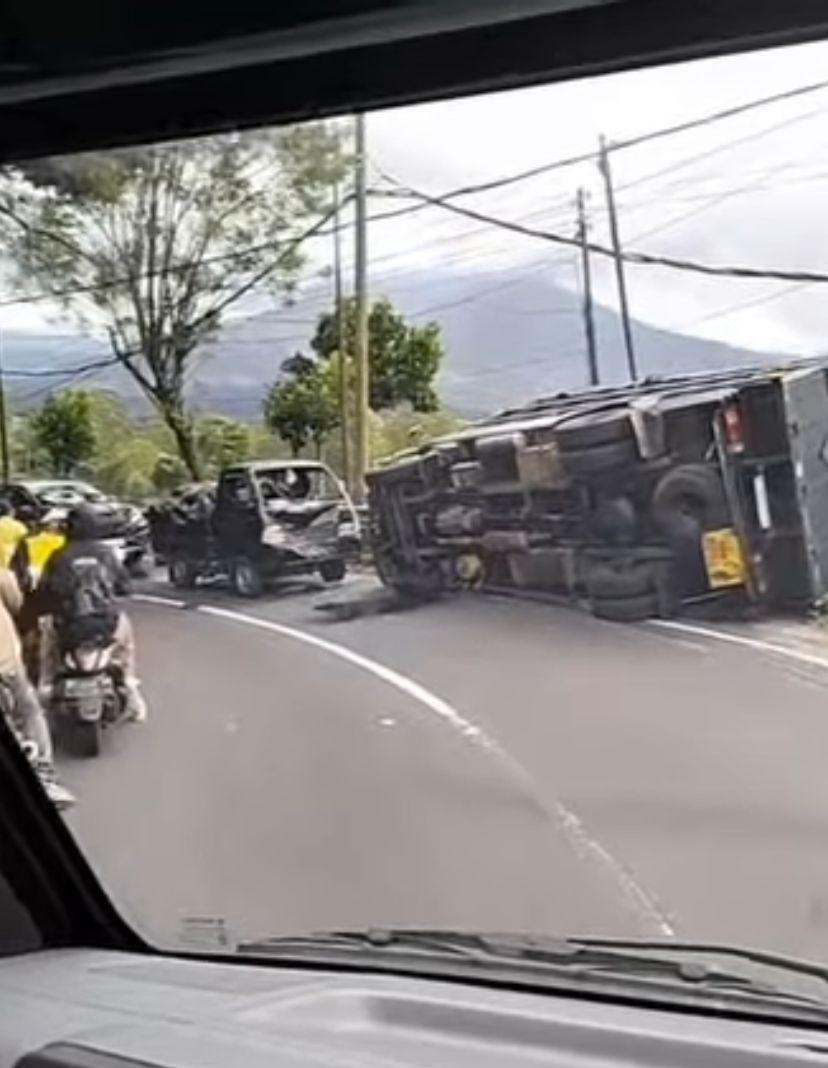 TERGULING: Truk terguling usai menabrak pikap di kawasan Penelokan, Kintamani, Bangli akibat rem blong.
