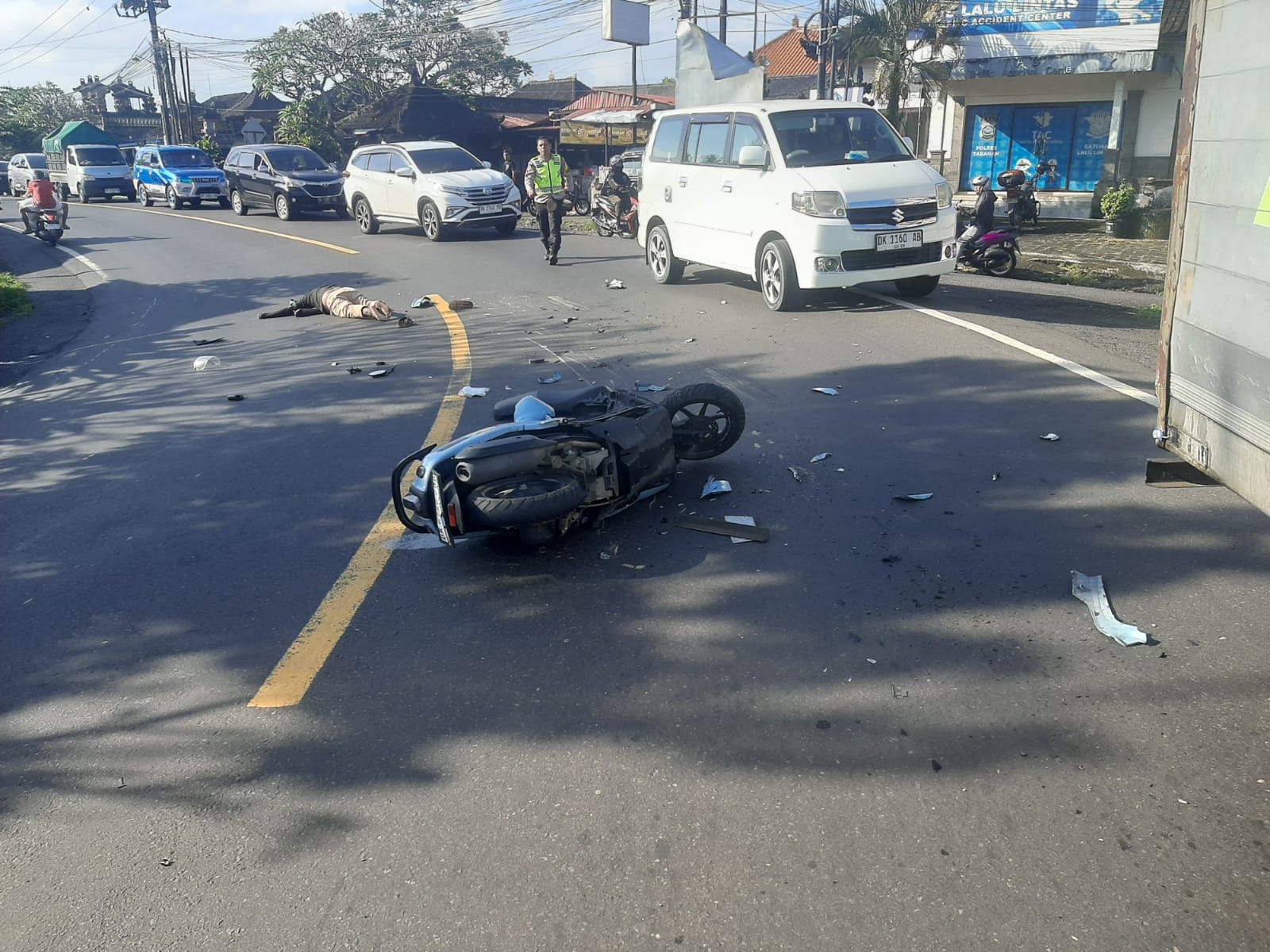 TERPENTAL: Sepeda motor terpental usai tabrak mobil box di jalur tengkorak Tikungan Simpang Megati, Tabanan, Senin (9/6) pagi.