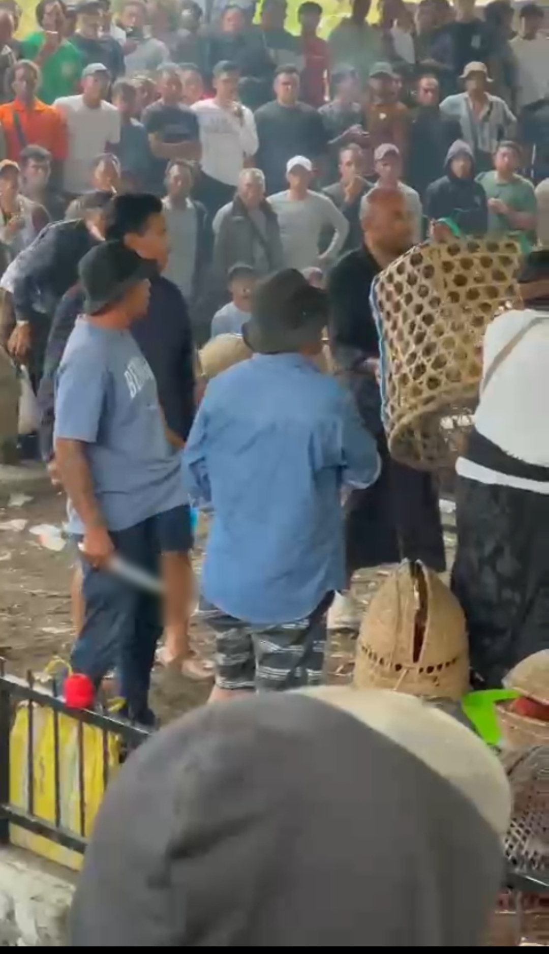 Tangkapan layar sosok diduga Mangku Luwes tertangkap kamera membawa sajam di arena tajen. (Bali Express/Istimewa)