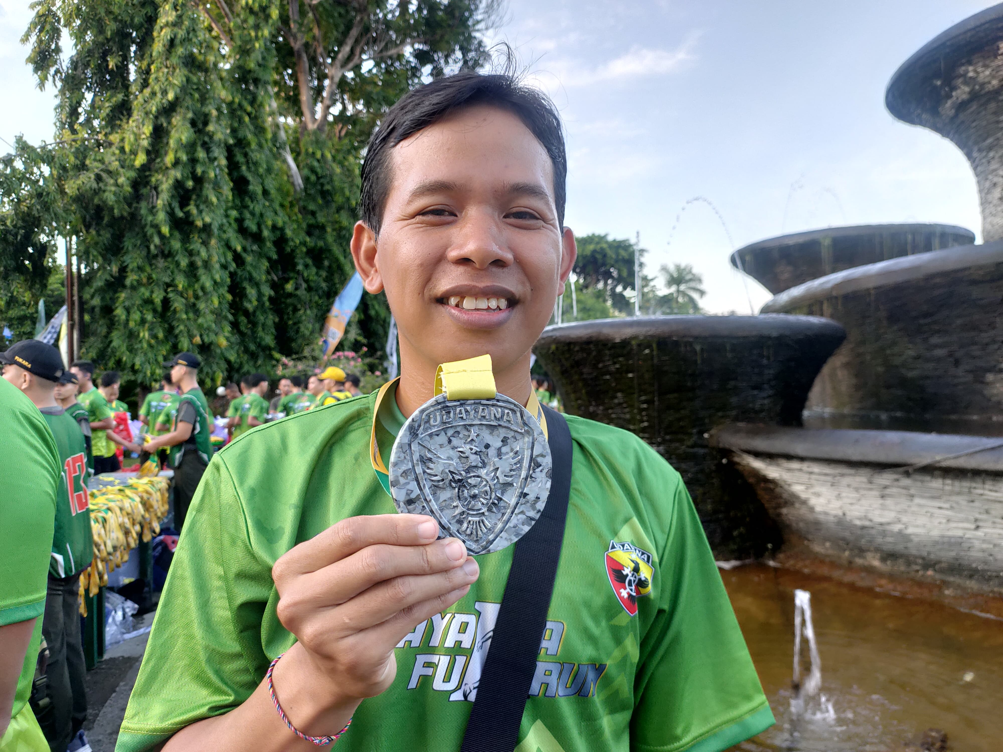 Komang Yudayana, finisher Udayana Fun Run dengan medali dari sampah plastik.