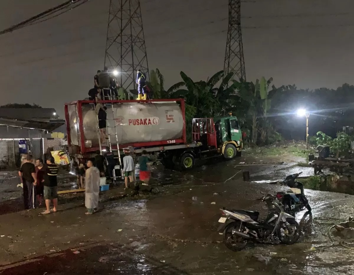 Damkar Pos Krian berupaya untuk menyelematkan korban dari dalam truk tangki di Jalan Raya Bypass Krian, Sidoarjo. Dua orang meninggal diduga keracunan residu oli bekas.