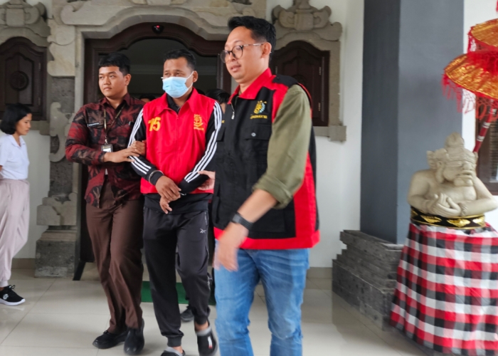 TERSANGKA: IWS (rompi merah) digiring untuk menuju Lapas Kelas IIB Karangasem.