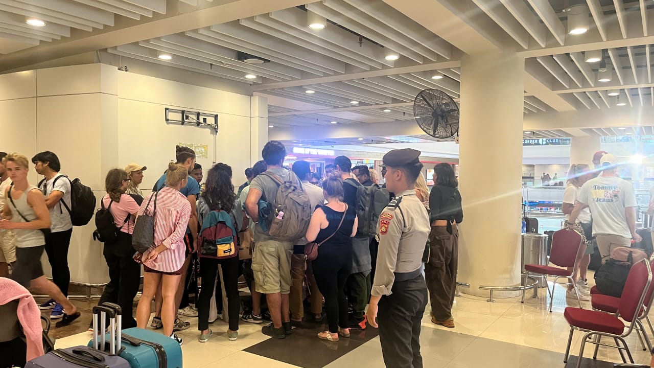 AMANKAN: Personil Polres Bandara Ngurah Rai melakukan pengamanan di Terminal Keberangkatan Internasional imbas pembatalan penerbangan ke Qatar. (Bali Express/Istimewa)