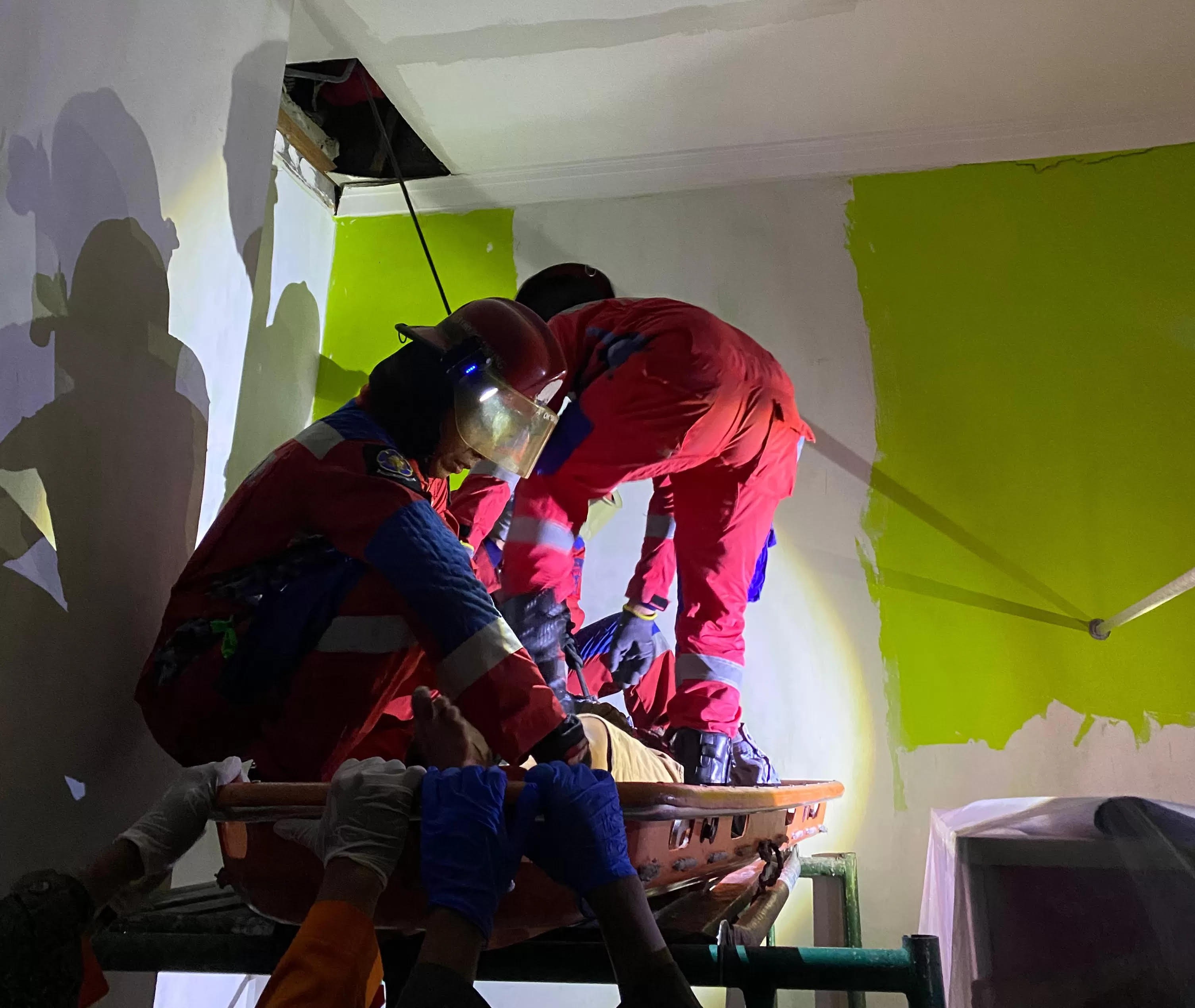 EVAKUASI: Petugas Tim Rescue DPKP Surabaya mengevakuasi korban Iskandar ditemukan tewas di plafon rumah Imam warga Jalan Griya Benowo Indah II Blok T Pakal.