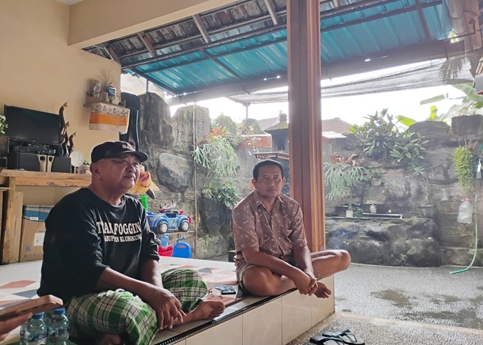MENANTI : Kelian Adat Nesa, Nyoman Arjana (topi hitam) dan kakak korban I Putu Suparno menanti kabar korban tenggelamnya KMP Tunu Pratama Jaya, Jumat (4/7/2025).