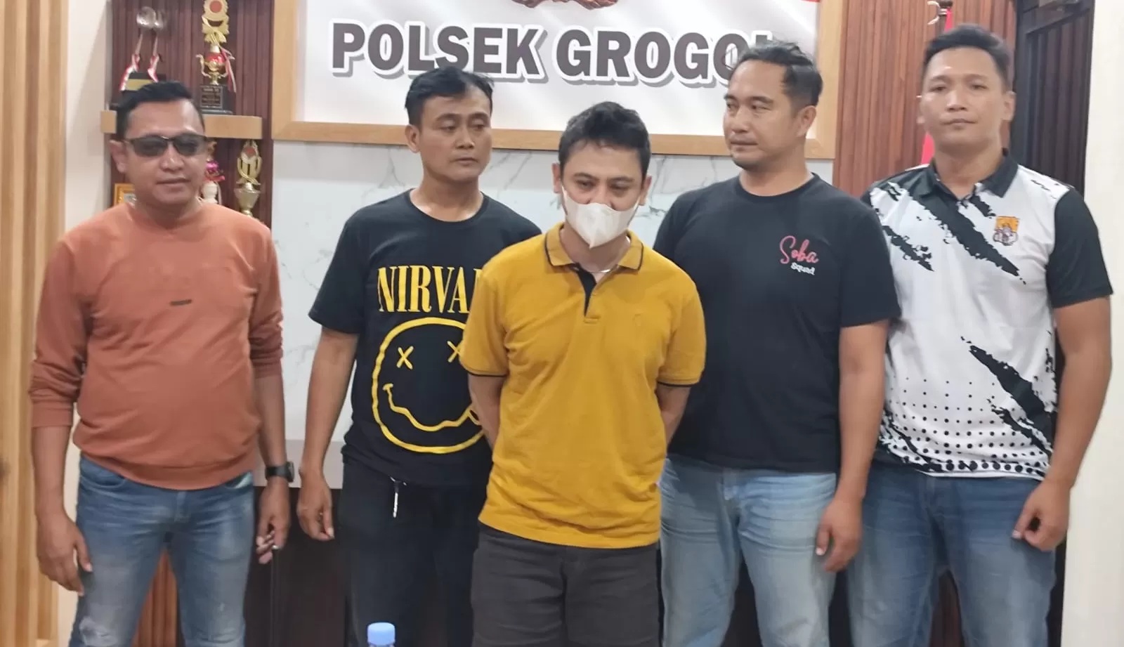 Panji Guruh alias Anji bin Usamah Al Uut (pakai masker) warga Pasar Kliwon, Kota Solo yang mengaku anggota polisi dibekuk. (Iwan Kawul/Radar Solo)