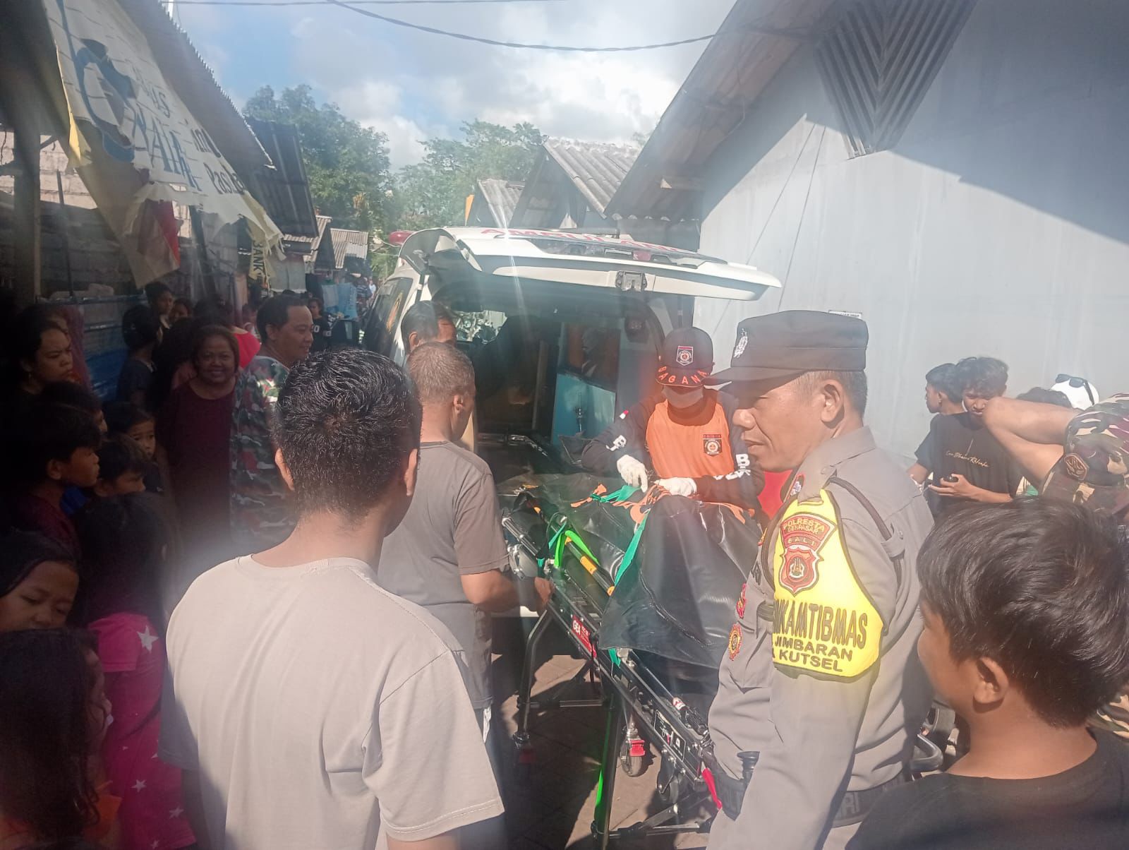 Petugas mengevakuasi jenazah RRW menggunakan ambulance. (Bali Express/Istimewa)