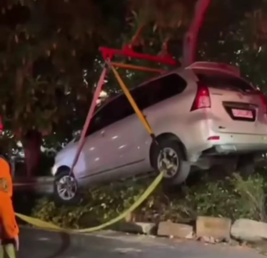 LAKA TUNGGAL : Petugas gabungan mengevakuasi mobil yang menabrak pembatas jalan di Jalan Semolowaru Surabaya, Sabtu (12/7).
