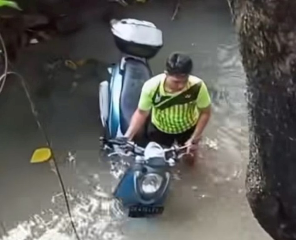 TERJUN: Sepeda motor yang diniki bule terjun ke sungai di Jalan Umalas Canggu, Badung.