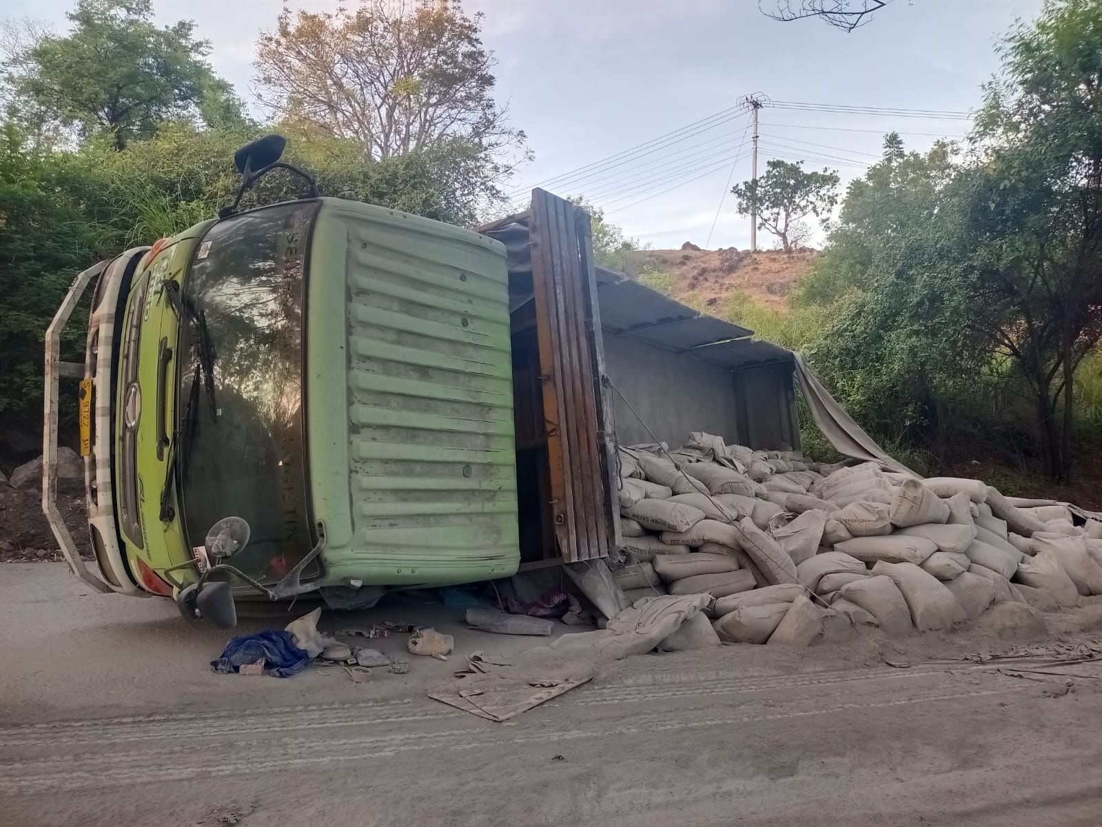TERGULING: Sebuah truk dengan nomor polisi S 9722 UE mengangkut semen terguling di jalur Amlapura-Singaraja, tepatnya di Desa Tulamben, Kubu, pada Selasa (15/7).