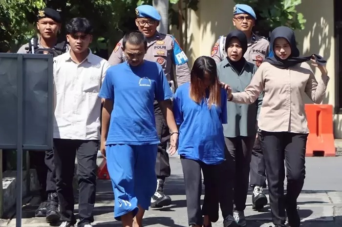DIGELANDANG: Tersangka NS dan suaminya, FA, 23, warga Dukun, Kabupaten Magelang saat digelandang petugas Polresta Magelang, Kamis (17/7/2025).