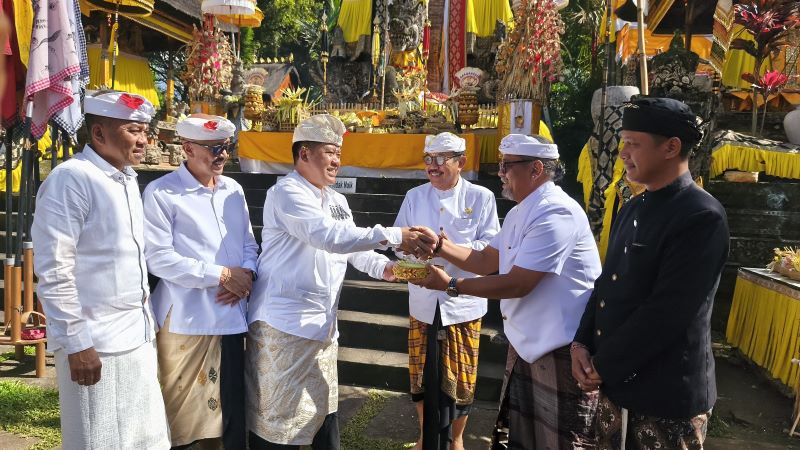 Bupati Bangli Sang Nyoman Sedana Arta (kiri) menyerahkan punia di sela-sela ngaturan bhakti penganyar di Pura Mandara Giri Semeru Agung, Lumajang, Jawa Timur, Kamis (17/7/2025).