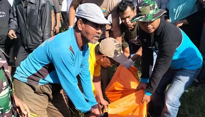 Warga mengevakuasi korban pembunuhan yang jenazahnya dibuang di sungai Payaman, Sukodermo, Purwosari, Pasuruan, Jumat (18/7/2025).