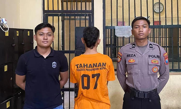 MERINGKUK: Dua petugas mengapit SH yang ditetapkan sebagai tersangka atas pelanggaran UU Darurat. Ia ditangkap usai kedapatan membawa pedang.