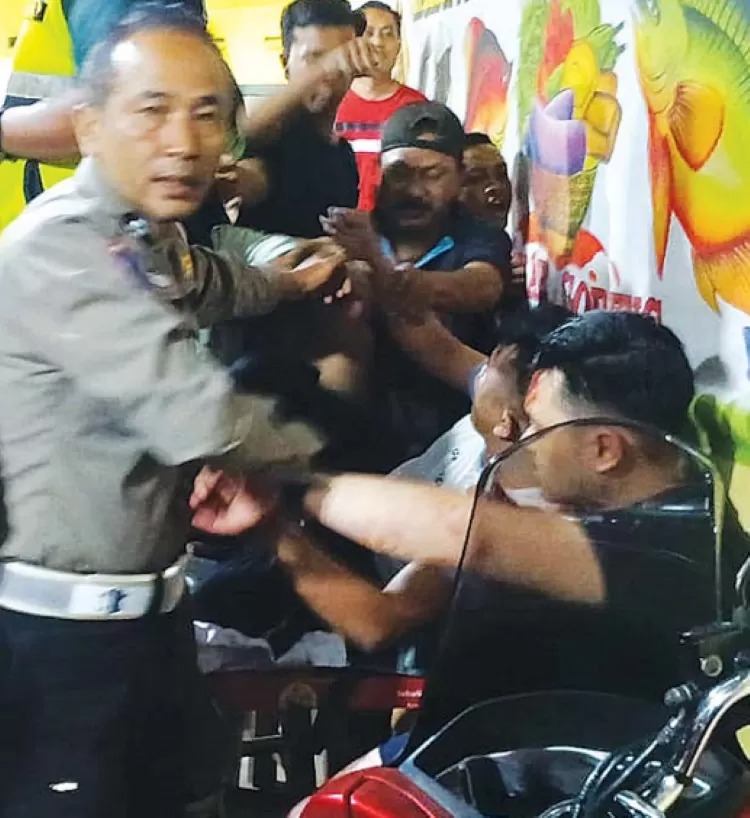 Seorang anggota Polsek Singosari mengamankan dua pelaku curanmor yang dihajar massa.