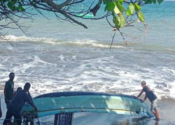 Petugas BPBD Jembrana dibantu warga  mengevakuasi perahu milik nelayan di perairan Candikusuma, Kecamatan Melaya, Jembrana, Rabu (6/8).