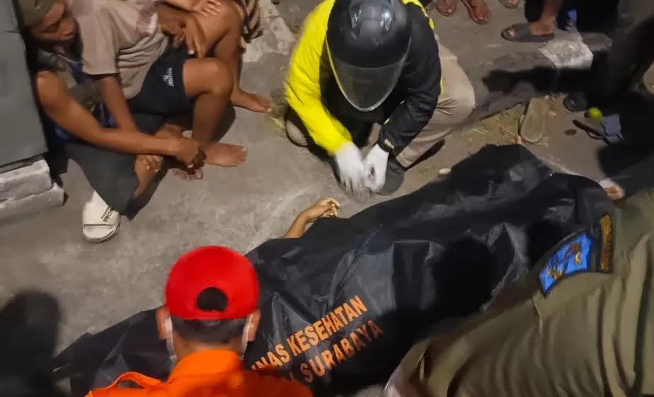 EVAKUASI : Petugas mengevakuasi korban meninggal usai ditabrak pengendara motor berboncengan tiga tanpa helm di Jalan Kenjeran, Surabaya.