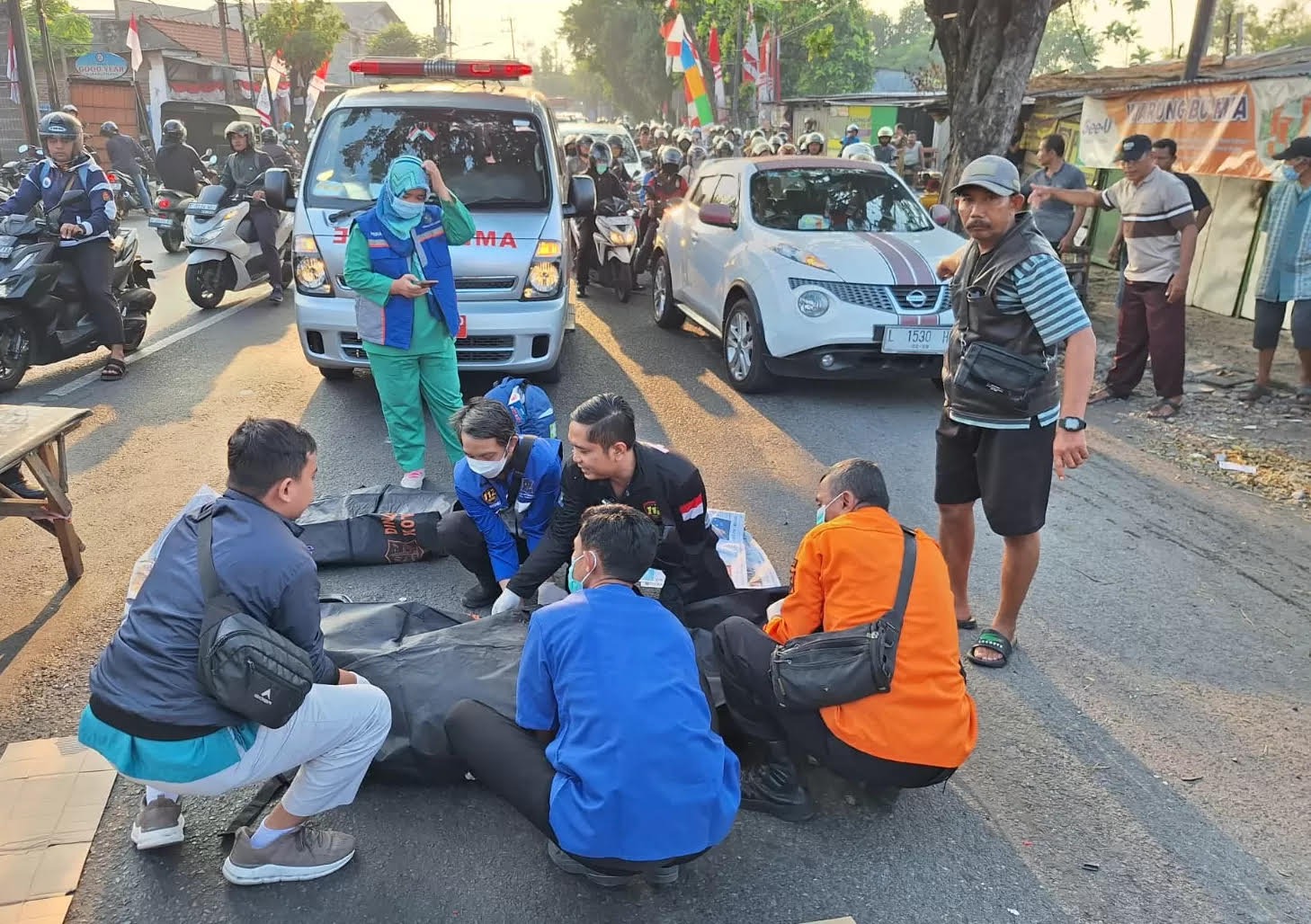 EVAKUASI : Petugas mengevakuasi jenazah korban pelajar yang terlintas truk di Jalan Mastrip, Karangpilang, Surabaya.