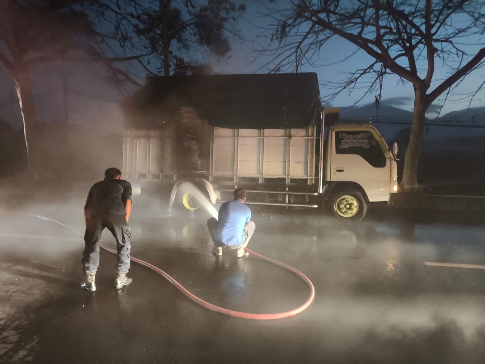 Petugas saat melakukan pemadaman terhadap kendaraan truk pengangkut ternak yang terbakar di sebelah barat Pertamina Kaliakah, Kecamatan Negara, Kabupaten Jembrana, Senin (11/8/2025).