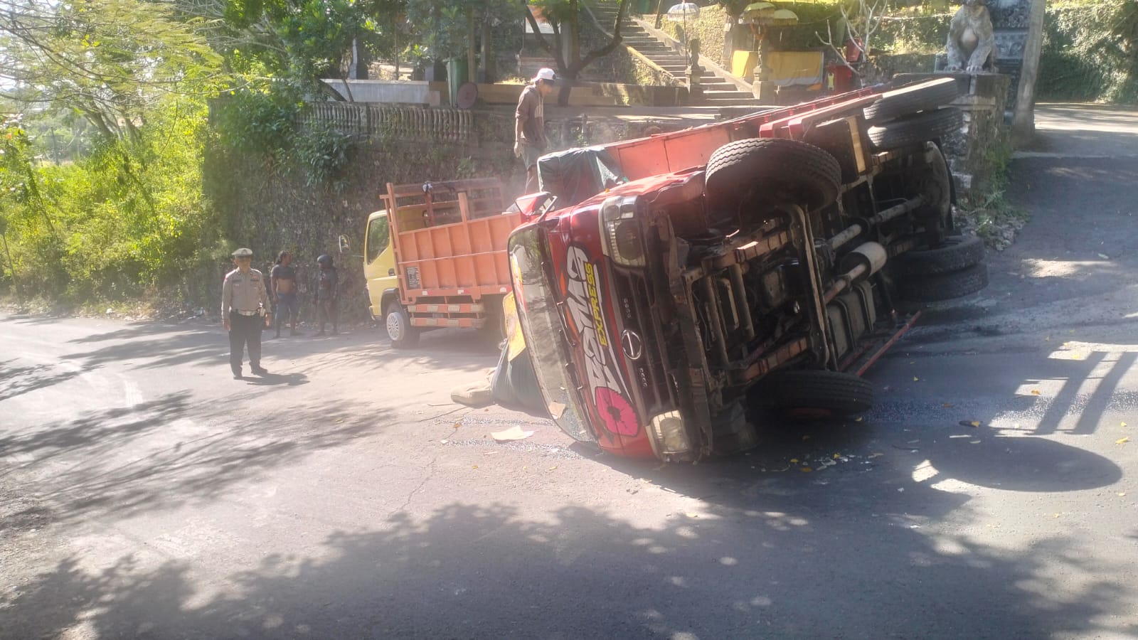 Terguling: Truk Hino muat semen terguling di Tanjakan Goa Gong. (Bali Express/Istimewa)
