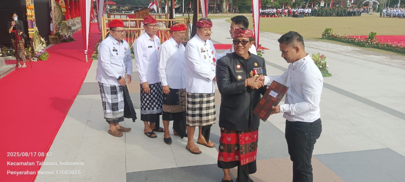 dua orang Warga Binaan Lapas Tabanan menerima remisi secara simbolis dari Bupati Tabanan di hadapan seluruh peserta upacara didampingi oleh Kepala Lapas (Kalapas) Tabanan, Prawira Hadiwidjojo