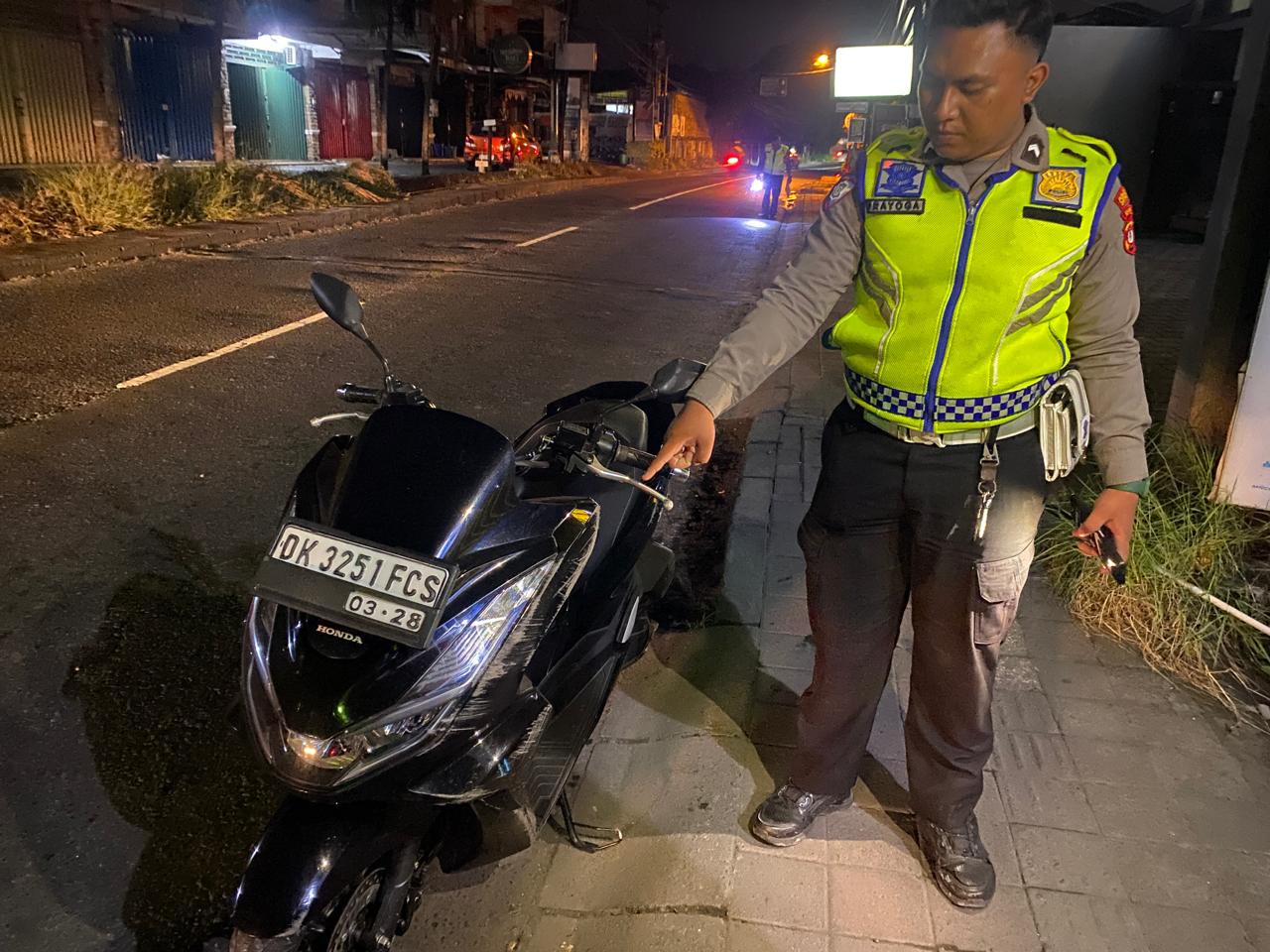 Petugas kepolisian menunjukan sepeda motor yang alami kecelakaan maut di Jalan Gunung Soputan, hingga menyebabkan pengendaranya tewas. (Bali Express/Istimewa)