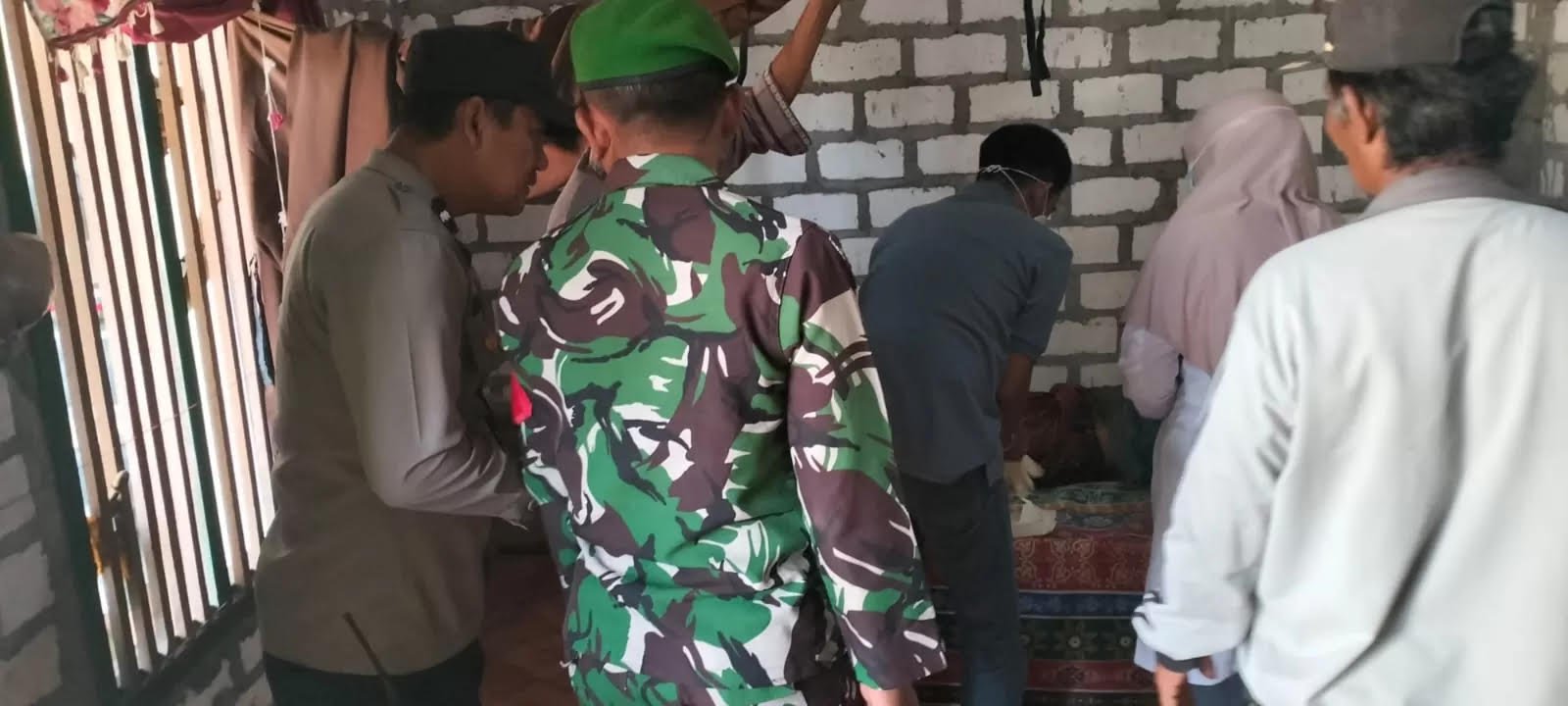 Anggota Polsek Benjeng dibantu tim medis dan warga melakukan evakuasi korban kesetrum di persawahan Dusun Jogodalu, Desa Jogodalu Kecmatan Benjeng, Gresik.