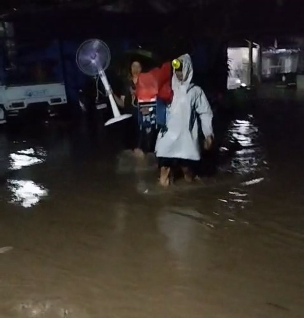 Warga Jembrana berupaya menyelamatkan barang dari genangan air.
