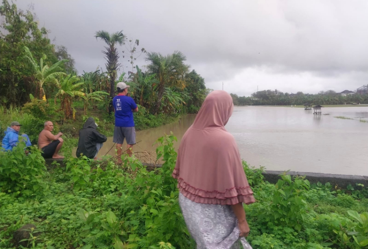 PADATI TKP : Warga memadati lokasi hilangnya korban akibat terseret arus banjir di Banjar Munduk, Desa Pengambengan, Kecamatan Negara, Rabu (10/9).