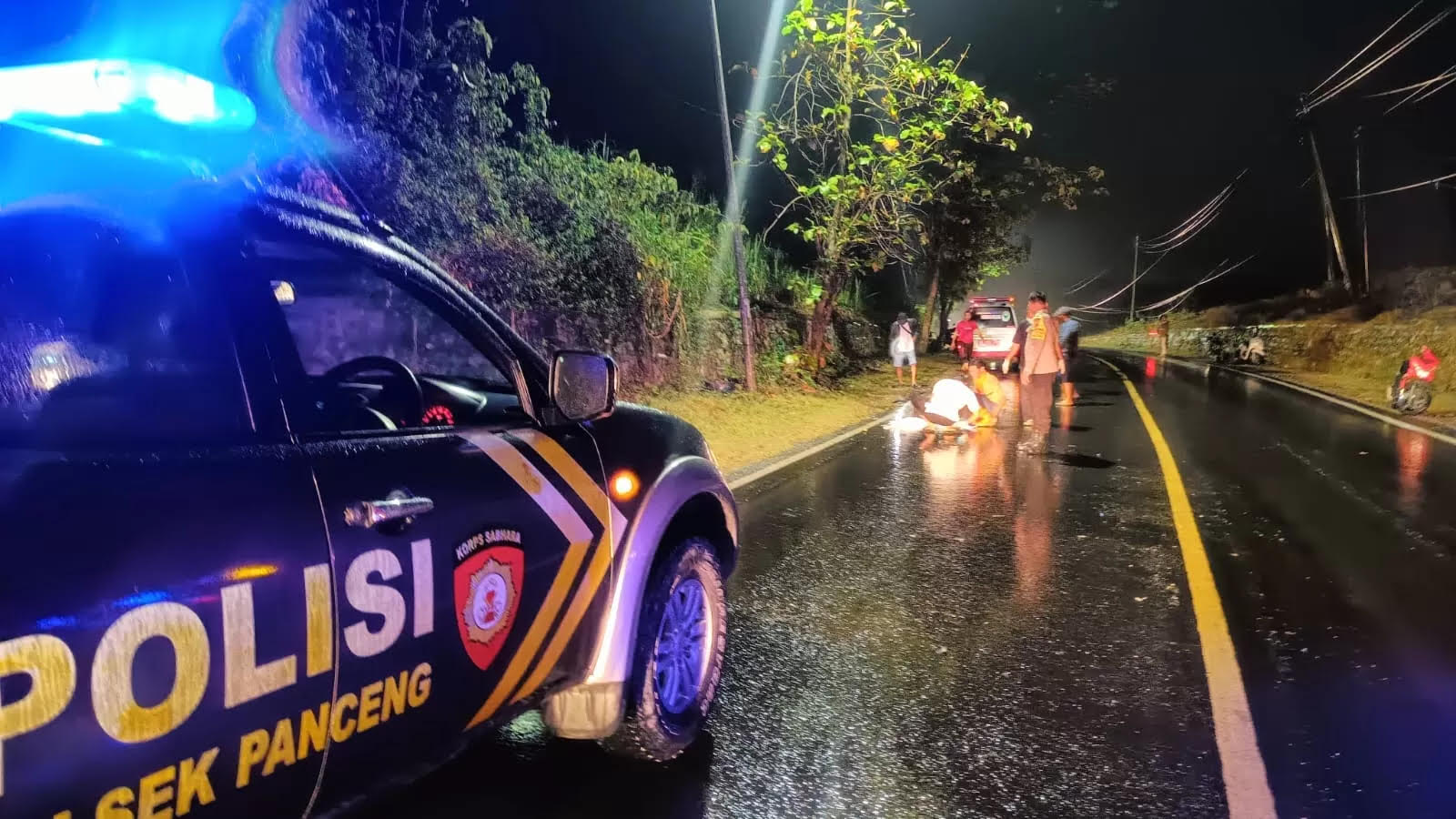 Petugas kepolisian saat melakukan evakuasi korban dan olah TKP Kecelakaan di Jalan Raya Desa Surowiti, Kecamatan Panceng, Gresik.