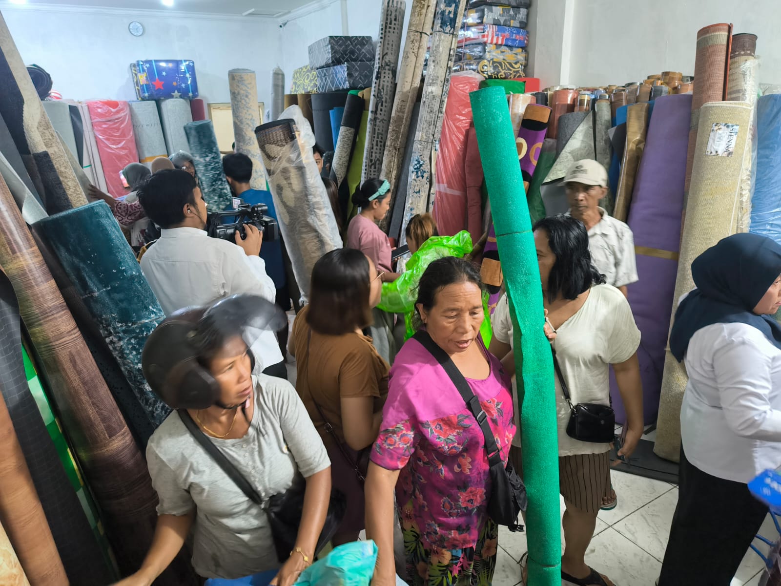 Warga berbondong-bondong membeli karpet di Jalan Gajah Mada, Denpasar setelah adanya diskon harga pasca banjir, Senin (15/9).