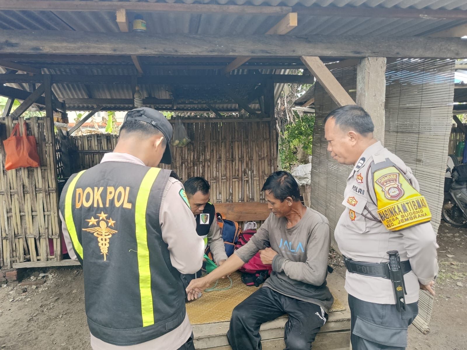 Tim Si Dokes Polres Jembrana memberikan pelayanan kesehatan gratis kepada warga terdampak banjir di Desa Budeng, Senin (15/9/2025).