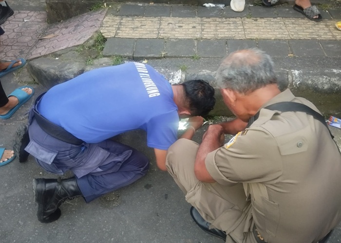 EVAKUASI : Personel Damkar berhasil mengevakuasi sebuah telepon genggam milik seorang pelajar yang terjatuh ke dalam gorong-gorong di Jalan Cempaka, Kelurahan Semarapura Klod, Kecamatan Klungkung.