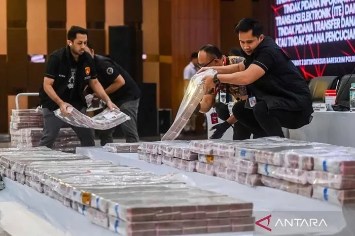 Sejumlah petugas memindahkan barang bukti uang tunai senilai Rp204 miliar untuk ditampilkan saat pengungkapan kasus pembobolan rekening pasif di Gedung Bareskrim Polri, Jakarta, Kamis (25/9/2025).