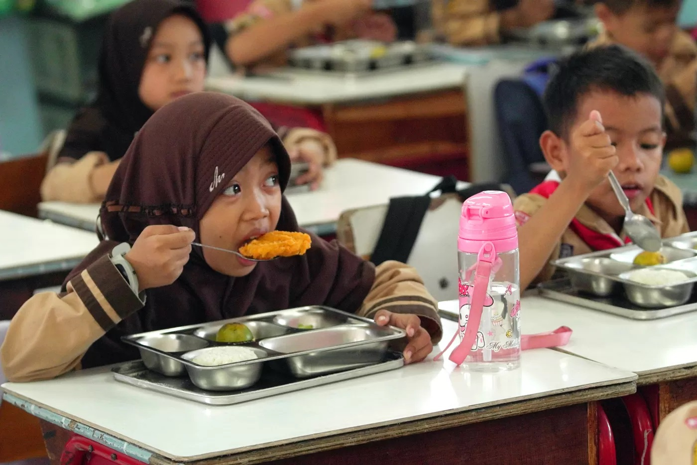 Siswa saat menyantap makanan pada program Makan Bergizi Gratis (MBG) di SDN 03 Jati Pulogadung, Jakarta.