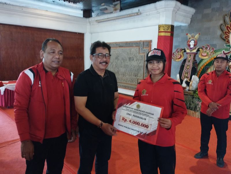 Wakil Bupati Gianyar Anak Agung Gde Mayun menyerahkan bonus kepada kontingen Gianyar peraih medali dalam ajang Porjar Provinsi Bali 2025, Selasa (30/9/2025) di Balai Budaya Gianyar.