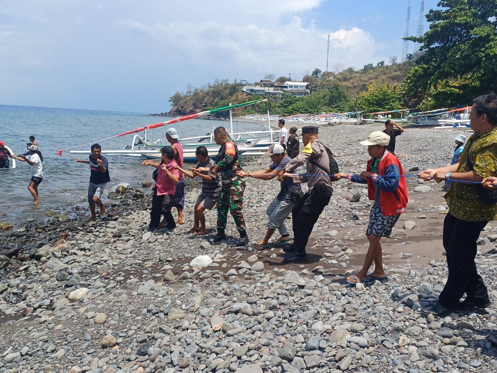 Warga dibantu TNI-Polri menarik perahu yang terbalik di di Perairan Banjar Bunutan, Desa Bunutan, Kecamatan Abang, Kabupaten Karangasem, Bali, pada Selasa (14/10/2025).