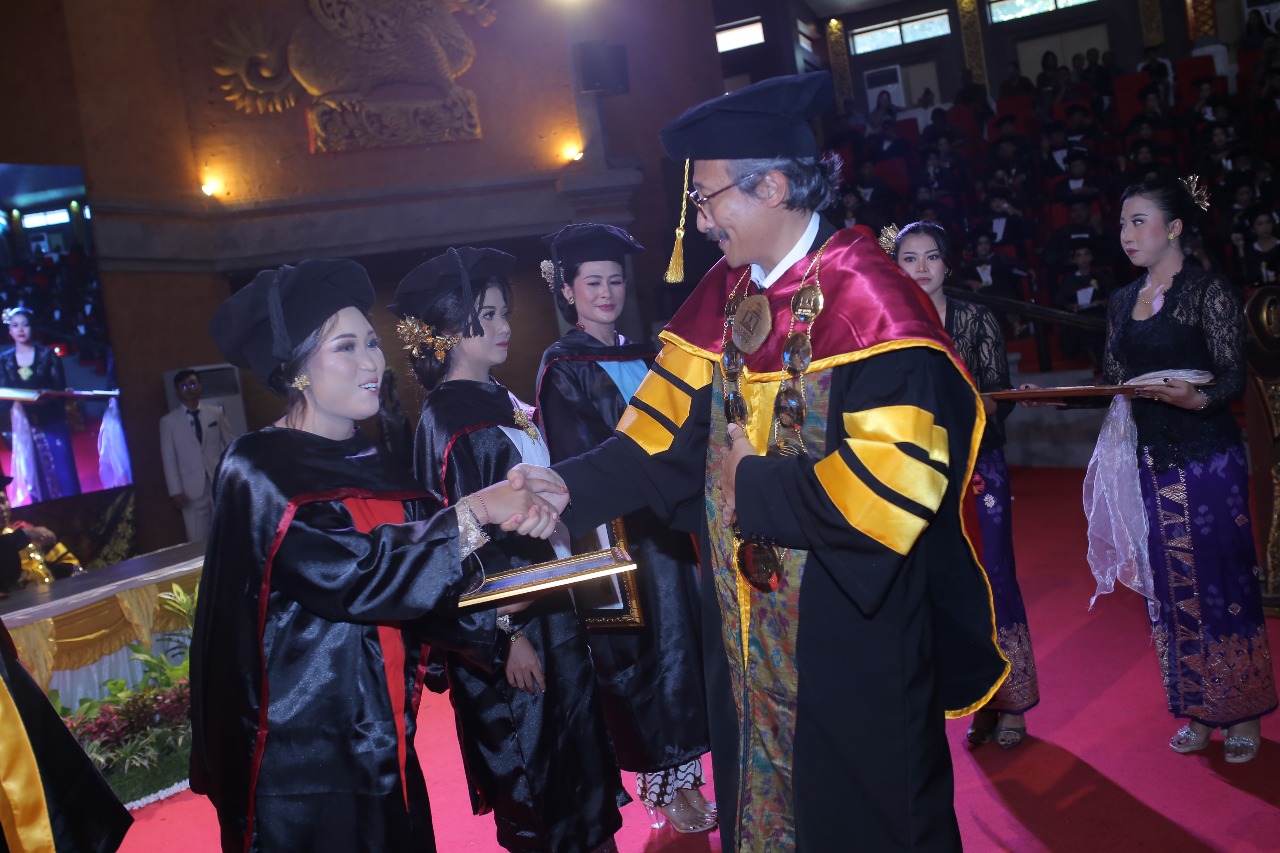 Rektor Institut Mpu Kuturan, Prof Suwindia saat menyerahkan penghargaan bagi wisudawan terbaik pada Jumat (31/10)