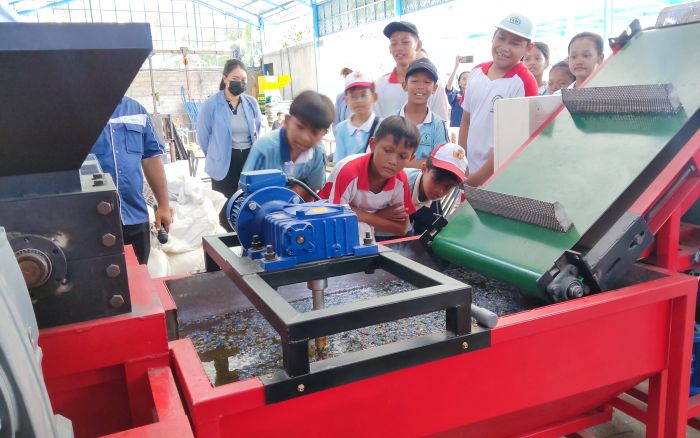 Para siswa dengan seksama memperhatikan proses pencacahan sampah plastik di Rumah Plastik Mandiri, Desa Petandakan, Buleleng.