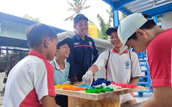 Memilah dan menyusun tutup botol menjadi hiasan dinding.
