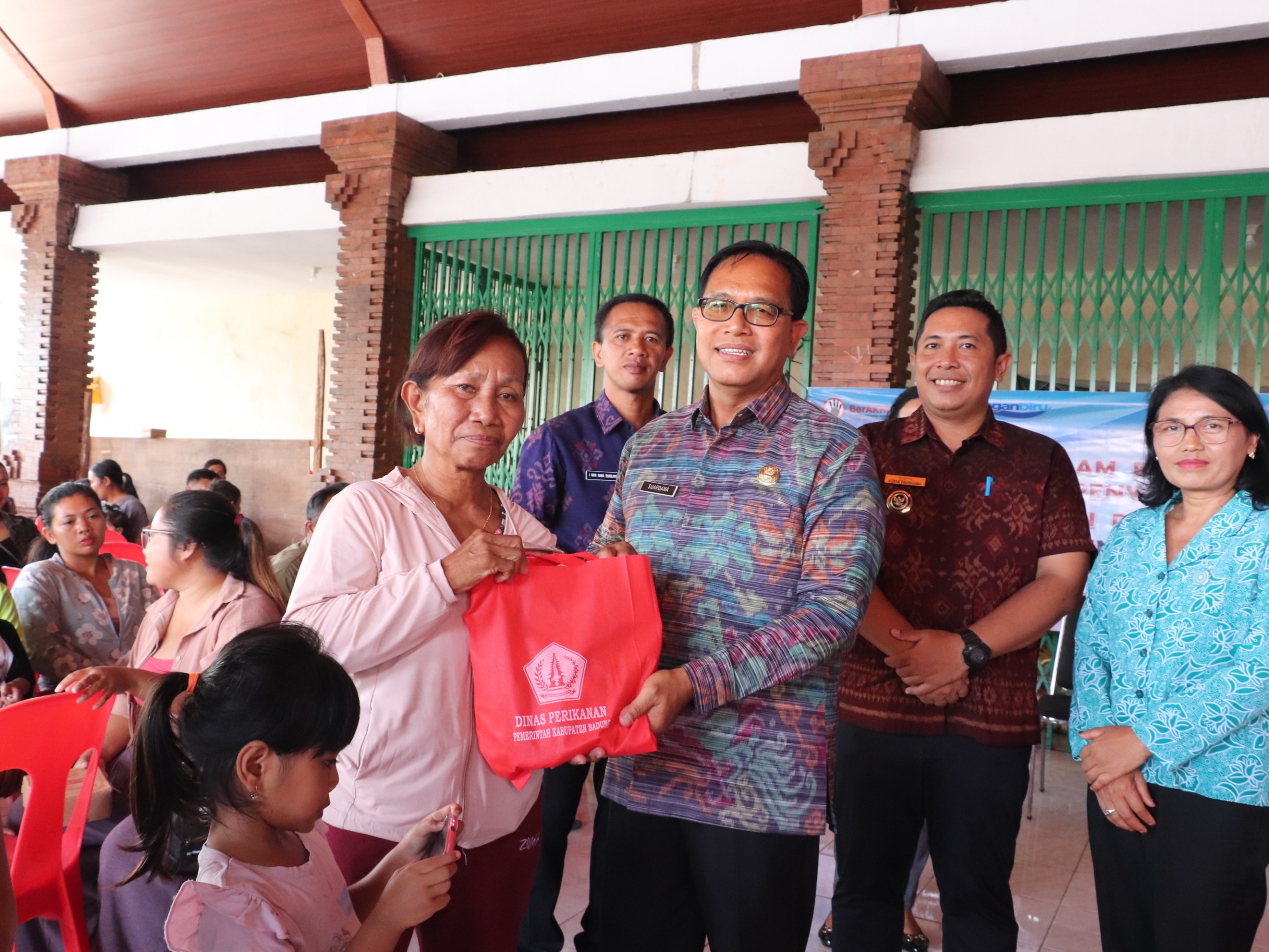 Kadis Perikanan Badung, I Nyoman Suardana saat menyerahkan paket olahan ikan di Balai Serba Guna Banjar Cabe, Desa Darmasaba, Kecamatan Abiansemal, Selasa (11/11).