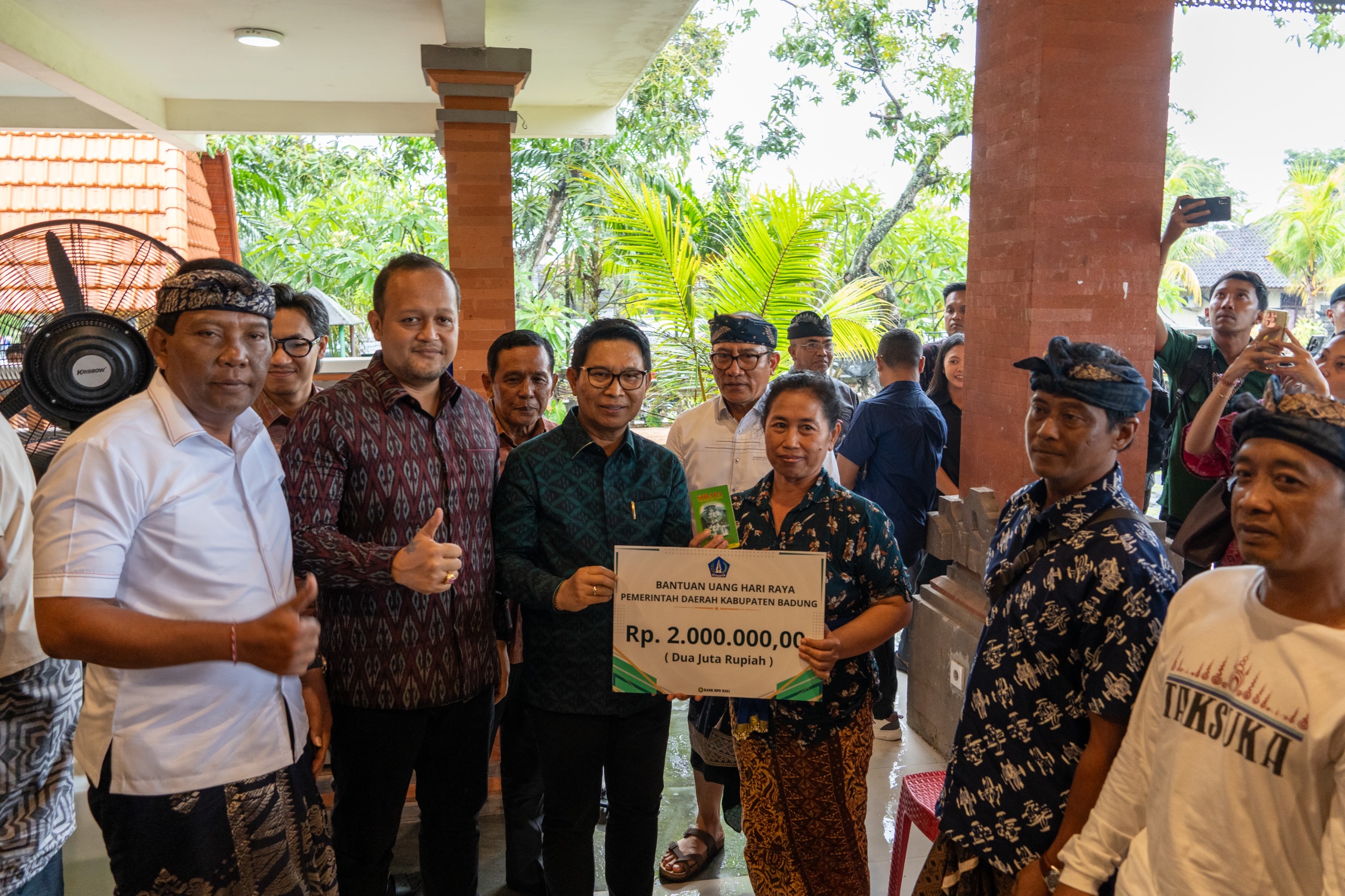 Bupati Adi Arnawa bersama Wabup Bagus Alit Sucipta menyerahkan secara simbolis bantuan Rp 2 juta per KK di Wantilan Desa Adat Padang Luwih, Dalung, Kuta Utara, Selasa (11/11).
