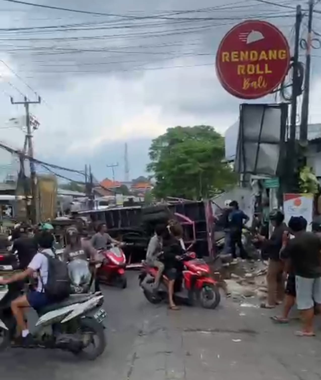 Tangkapan layar truk muat pasir terguling di Jalan Uluwatu, hingga membuat seorang pengantar gas meregang nyawa.