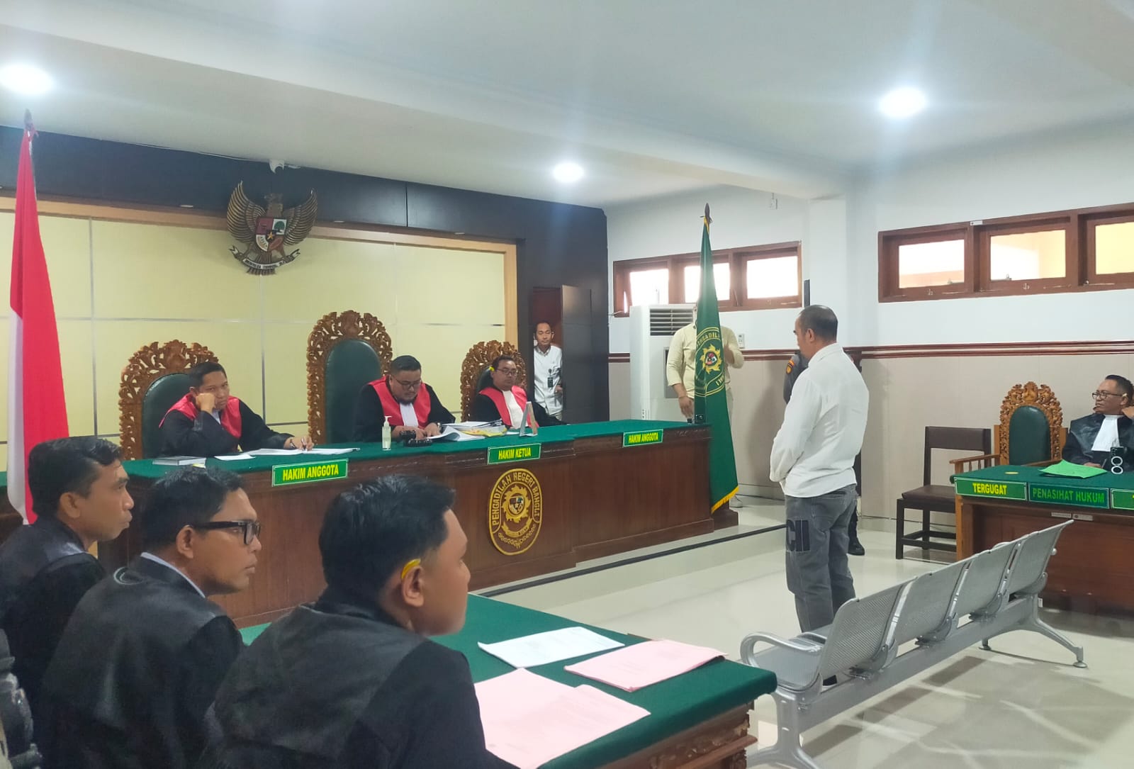 I Wayan Luwes alias Mangku Luwes berdiri saat mendengar putusan dari majelis hakim Pengadilan Negeri (PN) Bangli, Kamis (13/11/2025).