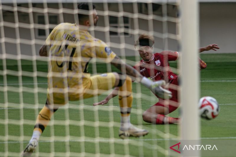 Penyerang Persis Solo Kodai Tanaka (kanan) mencetak gol ke arah penjaga gawang Arema FC pada pertandingan BRI Super League 2025-2026 di Stadion Manahan, Solo, Minggu (28/9/2025).